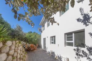 an external view of a white house with a patio at Oyster Catcher in Cape St Francis