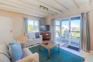 a living room with a couch and a table at Oyster Catcher in Cape St Francis