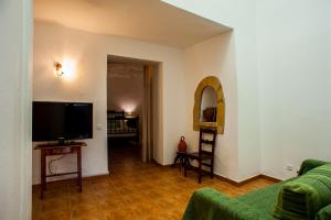 a living room with a couch and a flat screen tv at Casa Cueva El Molino in Artenara