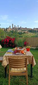 B&B Il Fienile San Gimignano في سان جيمنيانو: طاولة عليها طعام مطلة على مدينة