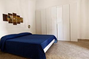 1 dormitorio con 1 cama azul y armarios blancos en Al Chiaro di Luna, en Marsala