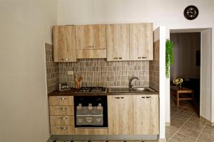 una cocina con armarios de madera y fregadero en Al Chiaro di Luna, en Marsala