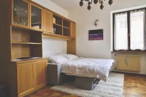 um quarto com uma cama, uma secretária e uma janela em Baita del me Remo, in the heart of Levico Terme em Levico Terme