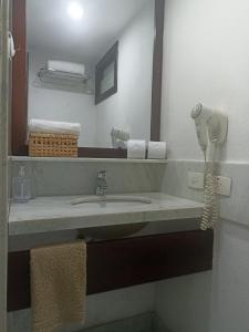 a bathroom with a sink with a phone and a mirror at Nas areias de Ponta Negra - Araça-309 in Natal