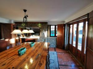 a dining room with a wooden table and a kitchen at Casa do Faial - Braga in Braga