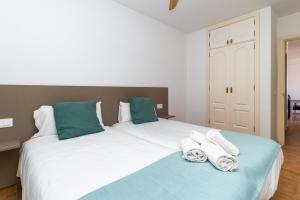 1 Schlafzimmer mit 2 Betten und grünen und weißen Handtüchern in der Unterkunft UpTown Urban Apartments in Corralejo