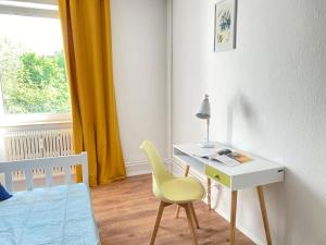 Schlafzimmer mit einem Schreibtisch, einem Stuhl und einem Bett in der Unterkunft SOMMER GARTEN neben Hbf Duisburg in Duisburg
