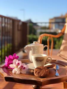 un vassoio con una tazza di caffè e fiori su un tavolo di Spacious apartment by the sea a Cannigione