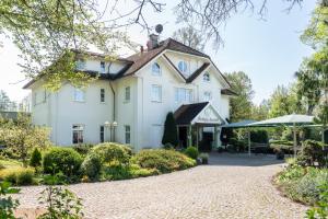 a large white house with a driveway at Parkhotel Neustadt Garni in Neustadt