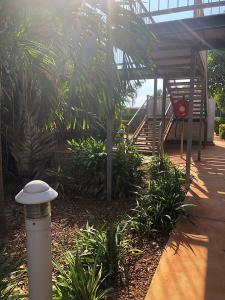 a patio with a staircase and a bench and plants at Hedland Accommodation in Port Hedland