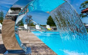 a pool with a water fountain in front of it at Kwatery Prywatne Dzika Roza in Darłowo