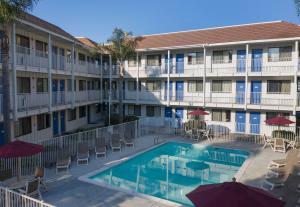 - Vistas a la piscina de un hotel con sillas y sombrillas en Motel 6-Carpinteria, CA - Santa Barbara - North en Carpinteria