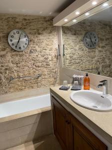 La salle de bains est pourvue de 2 réveils sur le mur et d'un lavabo. dans l'établissement La Borie en Provence, à Gordes