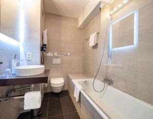 a bathroom with a tub and a toilet and a sink at Hotel Best Western City Centre in Brussels