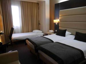 a hotel room with two beds and a window at Hotel Best Western City Centre in Brussels