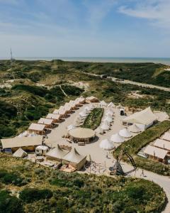 an aerial view of a beach with tents and the ocean at Beachcamp Bloemendaal Surf Resort in Overveen