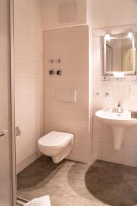uma casa de banho com um WC e um lavatório em Parkhotel Neustadt Garni em Neustadt