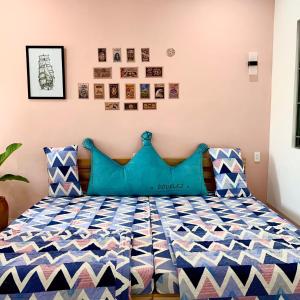 a bedroom with a bed with blue pillows at 1984House in Quy Nhon