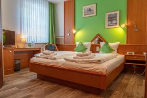 a bedroom with a bed with a green wall at Parkhotel Neustadt Garni in Neustadt