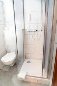 uma casa de banho com um chuveiro e um WC. em Parkhotel Neustadt Garni em Neustadt