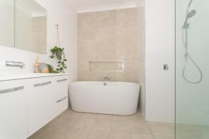 een witte badkamer met een bad en een douche bij The Riverview in North Haven