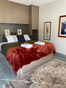 a bedroom with a large bed with a red blanket at SALT Luxury Couples Villa in Venus Bay +15 photos