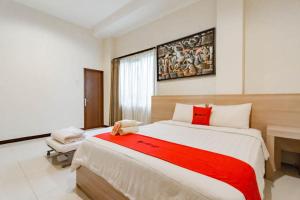 1 dormitorio con 1 cama grande con manta roja en RedDoorz near Lembang Park & Zoo 2, en Lembang