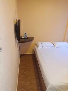 1 dormitorio con 2 camas y TV en la pared en Hotel Duke en Singapur