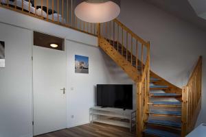 a living room with a staircase and a television at Apartment Inge in Greifswald