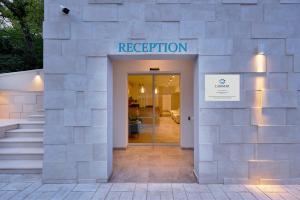 a entrance to a building with a sign that reads reception at Garni Hotel Larimar in Budva