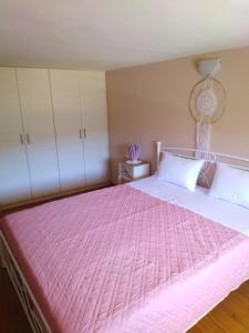 - une chambre avec un grand lit rose et des placards blancs dans l'établissement Arhontiko Katerina Spili, à Árdhaktos