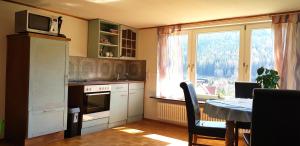 a kitchen with a table and a microwave and a window at Ferienhof Ziegler- Sonnenschein in Baiersbronn