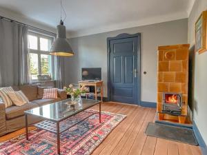 a living room with a coffee table and a fireplace at traumHaff denkmalgeschützter Amalienhof Sauna, offener Kamin, Hund in Gegensee