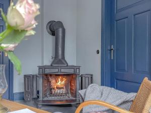 a fireplace in a room with a table and a blue door at traumHaff denkmalgeschützter Amalienhof Sauna, offener Kamin, Hund in Gegensee