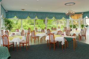 a dining room with white tables and chairs at Parkhotel Neustadt Garni in Neustadt