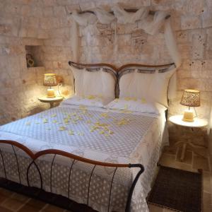 a bedroom with a white bed with two lamps at I Trulli Di Nonno Giovanni in Alberobello