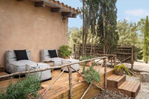 une terrasse en bois avec des canapés sur une maison dans l'établissement Agroturismo Son Fogueró - Adults Only, à Maria de la Salut