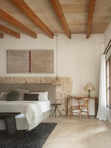 a bedroom with a bed and a desk and a table at Agroturismo Son Fogueró - Adults Only in Maria de la Salut