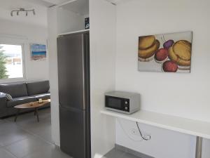 a kitchen with a refrigerator and a living room at The Anemoni 5 Villa in Protaras