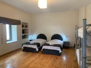 Duas camas num quarto com pisos em madeira em Hotel Lemi em Mestia