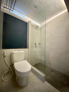 a bathroom with a toilet and a glass shower at Bukit Tiga Lima Boutique Hotel in Sajang
