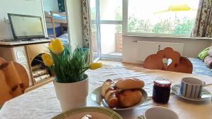 una mesa con un plato de comida y flores en ella en ELISABETH Haus KMB Seeappartement direkt am Ossiacher See mit Hallenbad Skiarena Gerlitzen en Bodensdorf