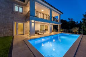 una casa con piscina frente a una casa en Villa Pafran with heated pool Krk en Krk