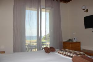 a bedroom with a bed with a view of the ocean at K Farm House in Kalavárda