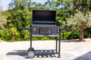 una parrilla de barbacoa en un stand en un parque en Villa Pafran with heated pool Krk, en Krk