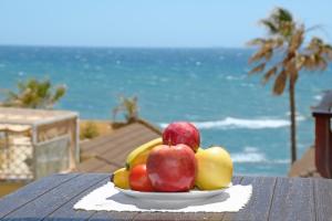 a plate of fruit on a table near the ocean at Casa Linda La Lubina, front the beach La Lucera, Riviera del Sol in Sitio de Calahonda