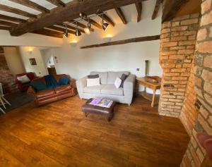 a living room with a couch and a table at Stoop Cottage - in the heart of Quorn in Quorndon