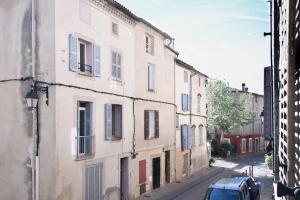 an old building with blue shutters on a street at La Cachette du Comte in Montfort-sur-Argens
