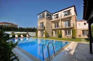 una casa grande con piscina frente a ella en Cesme Elysium Hotel, en Cesme