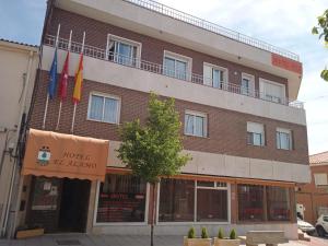 a large red brick building with flags on it at HOTEL El ALAMO MADRID in El Álamo